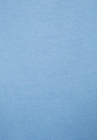 Jasnoniebieska dzianina, drobno fakturowana, o gładkiej powierzchni i równomiernym rozkładzie koloru. Brak widocznych wzorów lub dodatkowych detali.