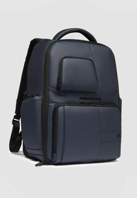 Zaino blu navy dal design elegante, realizzato in materiale liscio e resistente. Caratterizzato da molteplici tasche con zip e spallacci imbottiti.