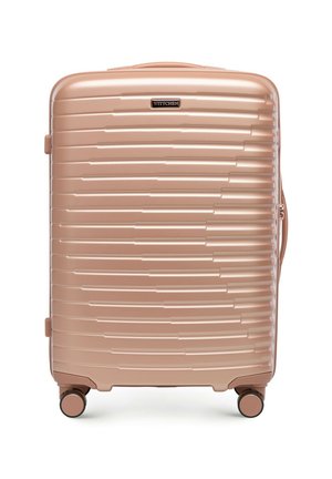 Valise rigide rose doré avec des rainures horizontales, quatre roulettes multidirectionnelles, une poignée latérale et une plaque de logo de marque sur le devant.