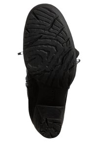 Semelle de chaussure noire avec des motifs de bande de roulement profondément texturés et un petit talon, affichant le nom de la marque "Gabor" embossé sur la zone de la voûte plantaire.