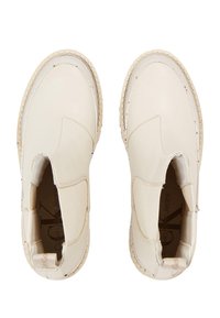 Stivali alla caviglia in pelle beige con pannelli elastici laterali e suola in gomma crema. Il design presenta accenti di cucitura minimi e una finitura liscia.