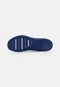 Semelle de chaussure en caoutchouc bleu avec un motif de grip texturé, présentant des rainures horizontales et des accents en relief pour l'adhérence.