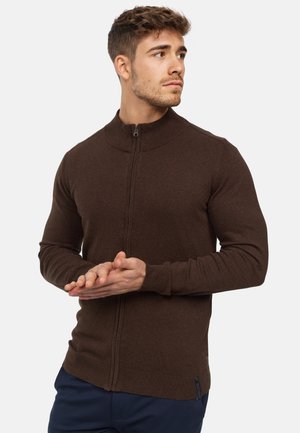 Brauner Reißverschluss-Pullover mit hohem Kragen, aus strukturiertem Stoff gefertigt. Verfügt über lange Ärmel und eine taillierte Silhouette, die sich gut zum Schichten eignet.