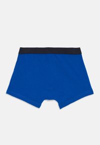 Blaue Herren-Boxershorts mit einem schwarzen elastischen Bund auf einem weißen Hintergrund, flach ausgelegt, um die Rückseite und die Nähdetails zu zeigen.