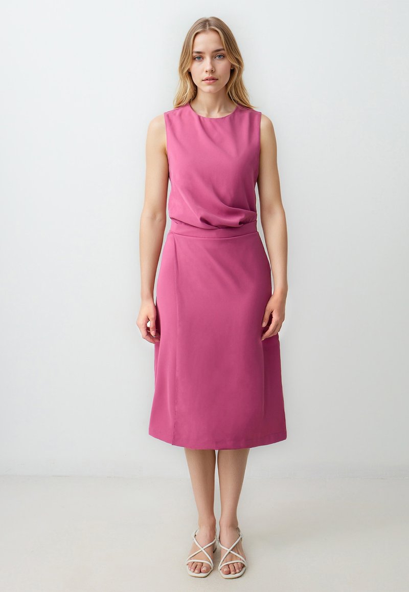 Fuchsia ärmelloses Kleid mit einem drapierten Ausschnitt, glatter Textur und Midi-Länge, kombiniert mit leichten Riemchensandalen.
