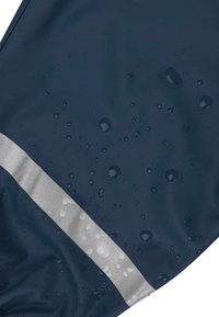 Navy wasserdichtes Gewebe mit Wassertropfen, ausgestattet mit einem matten silbernen reflektierenden Streifen entlang des Randes, glatter Textur und leichtem Schimmer.