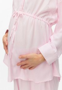 Blusa premaman a righe rosa e bianche, con vita arricciata, chiusura a bottoni e maniche lunghe. Tessuto morbido e vestibilità rilassata.