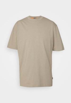 Beige bomuld T-shirt med rund hals, korte ærmer og en løs pasform. Har en subtil struktur og en lille orange detalje ved halsen.