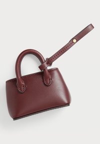 Malá bordová kožená kabelka s okrúhlymi držadlami, odnímateľným popruhom, hladkou textúrou a prešitými detailmi pozdĺž okrajov.