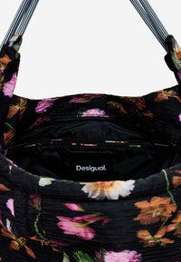 Black floral bag interior with pleated texture; features pink and orange flowers, a black lining, and a Desigual label at the base.