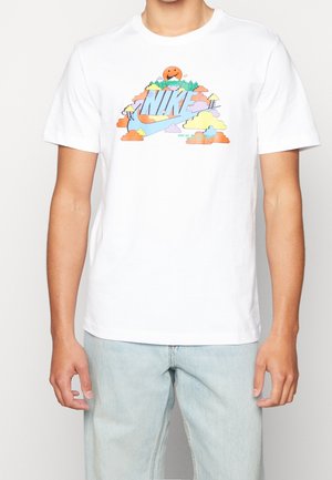 Weißes Baumwoll-T-Shirt mit einem bunten grafischen Design, das das Wort "Nike", Wolken, Bäume und eine lächelnde Sonne zeigt. Kurze Ärmel.