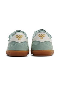 Zamszowo-skórzane sneakersy w miętowym zielonym i białym kolorze, z brązową gumową podeszwą i złotym logo na pięcie. Okrągły kształt, wyściełany kołnierz.