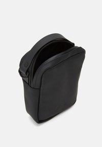 Borsa in pelle sintetica nera con texture liscia, forma rettangolare, manico superiore e chiusura con zip. Design minimalista con logo in rilievo.