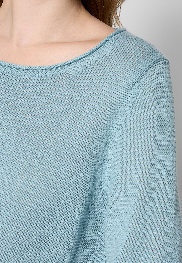 Helleblaue Strickjacke mit einem lockeren, weiten Ausschnitt und strukturiertem Stoff. Verfügt über gerippte Kanten und eine lässige Passform für hohen Tragekomfort.