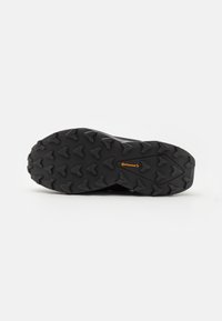 Black rubber shoe sole with aggressive tread pattern. Features a "Continental" logo in orange. Textured surface aids in traction.