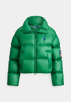 Casaco corta-vento verde com design curto, com fecho de correr frontal, punhos canelados e um logótipo azul. Inclui um emblema da bandeira americana na manga.