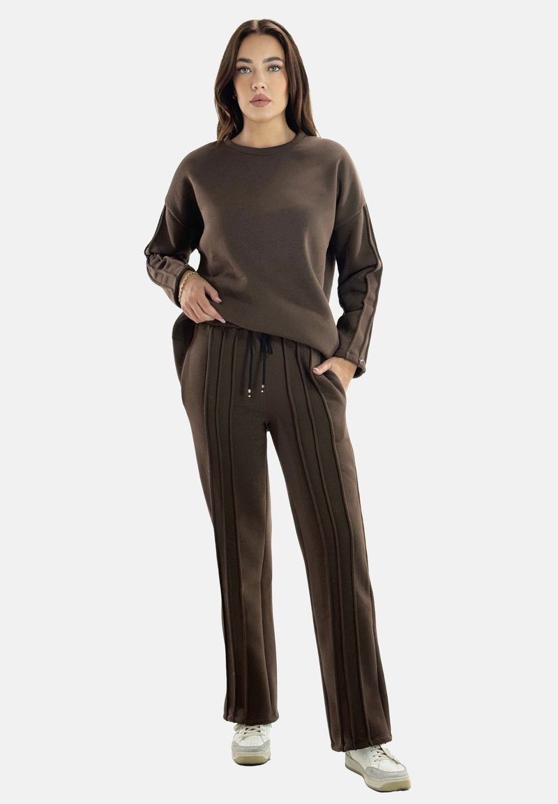 Brauner Pullover und passende Hose aus weichem Stoff. Der Pullover hat einen einfachen runden Ausschnitt; die Hose hat vertikale Streifen und einen Kordelzug.