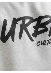 Un tessuto grigio presenta un audace lettering nero che recita "URB Culture", mostrando una texture liscia e uno stile di design informale.