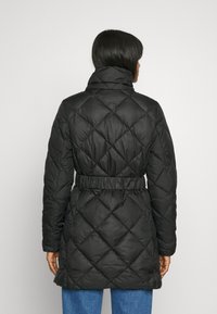 Black quilted puffer coat with a high collar, belted waist, and diamond pattern. The fabric appears smooth and lightweight, offering warmth.
