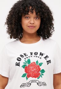 Weißes Baumwoll-T-Shirt mit einem roten Rosen-Design und grünen Blättern sowie dem Schriftzug "ROSE POWER TRUE LOVE" in fetter schwarzer Schrift.