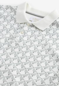 Polo shirt blanc avec un motif géométrique d'oiseaux gris, doté d'un col en rib et blanc et d'une patte de boutonnage à deux boutons.