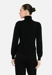 Maglione nero a collo alto con maniche lunghe, polsini a coste e una vestibilità aderente. Tessuto liscio e colore solido senza pattern o decorazioni.