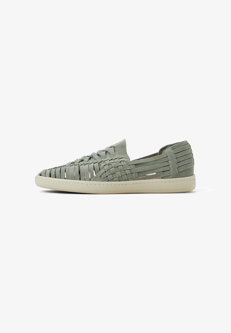 Light green suede slip-on shoes featuring woven upper design, side cutouts, and a cream rubber sole with textured detailing.