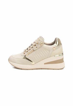 Sneaker beige con un accento dorato lucido, caratterizzato da un lato testurizzato, una zip decorativa e una suola a zeppa per l'elevazione.