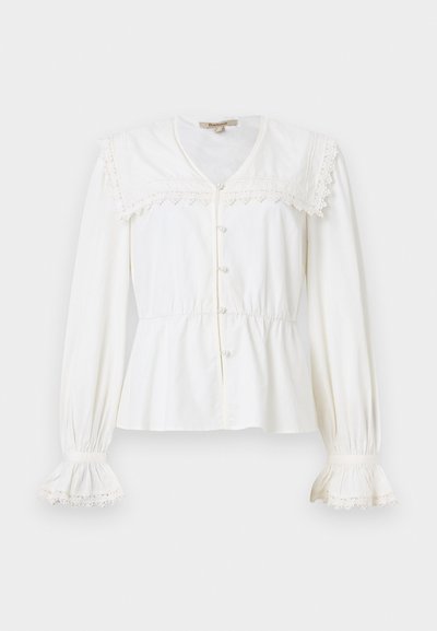 Blouse blanche à manches longues avec un large col orné de dentelle, boutons en perle sur le devant, poignets froncés et taille légèrement cintrée.