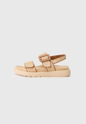 Sandali intrecciati beige con suola in schiuma beige, cinturini regolabili e fibbia quadrata. Presentano un tessuto testurizzato e una soletta imbottita per il comfort.