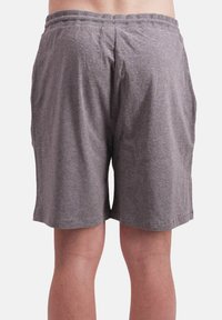 Graue Baumwollshorts mit elastischem Bund, die eine lockere Passform und ein schlichtes Design aufweisen. Der Stoff hat eine glatte Textur und eine legere Länge.