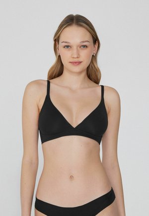 Bralette triangle noir avec de fines bretelles réglables, tissu lisse et décolleté en V. Design sans couture pour une esthétique minimaliste.