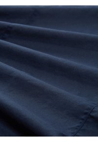 Tela azul marino con una textura suave, mostrando pliegues delicados y un acabado limpio, con detalles sutiles de costura y sin patrones visibles.