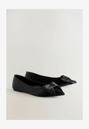 Musta lapikad jalanõud, mis on valmistatud siledast nahast, terava ninaga ja dekoratiivse paelaga ees. Minimalistlik disain madala ja tugeva kontsaga.