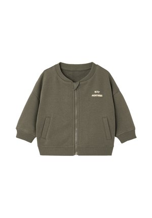 Child's olive green zip-up jacket with ribbed cuffs and hem, two front pockets, and "Petit Aventurier" text on the left chest.