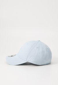 Boné de beisebol de algodão azul claro com uma aba curva, logótipos bordados na frente e na lateral, e ilhoses de ventilação na coroa.