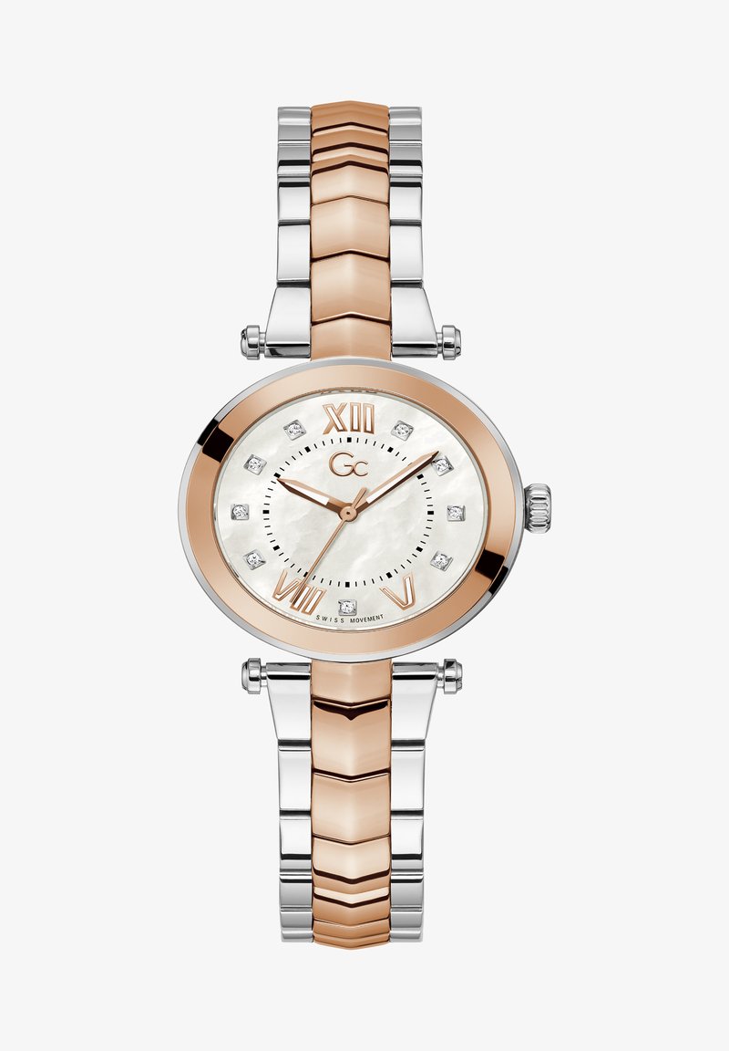 Roosa kuld ja hõbedane kell ümmarguse pärlmutterist kuvariga, Rooma numbritega ja teemantaktsentidega lingitud metallribal.