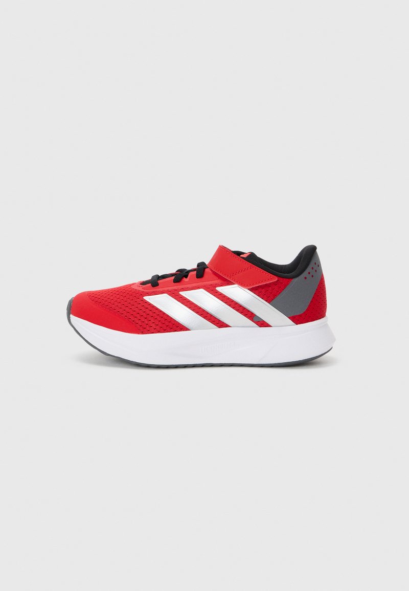 Red athletic shoe with mesh upper, black accents, white sole, and three white stripes on the side. Velcro strap at the ankle for support.