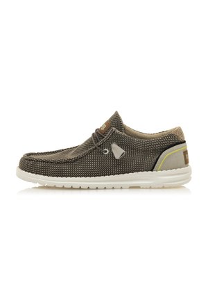 Zapato de tela marrón con un patrón texturizado, entresuela blanca y un acento de ante. Presenta un detalle de cordones y un logo en el costado. Forma redondeada.