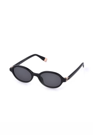 Lunettes de soleil ovales noires avec des verres foncés, des branches fines et de petits accents en or rose aux charnières et aux bouts des branches.