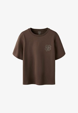 Brun t-shirt med korte ærmer med et lille firkløverdesign lavet af hvide prikker på venstre bryst.