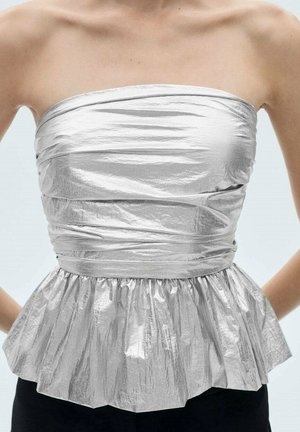 Haut métallique argenté sans bretelles avec tissu froncé et plissé, ajusté à la taille et évasé en style péplum.