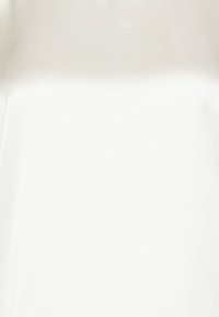 Tissu blanc et lisse avec une finition mate. Texture douce, légèrement réfléchissante sous la lumière, sans motifs ni accents distincts.