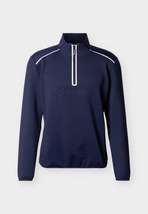 Pulover dugih rukava u mornarsko plavoj boji s bijelim patentnim zatvaračem i ukrasnim trakama na ramenima, s utisnutim logotipom Calvin Klein sprijeda.