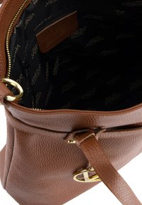 Sac à main en cuir marron avec une texture grainée, fermeture éclair dorée et un patch logo à l'intérieur. Doublé en tissu noir avec un logo répété.