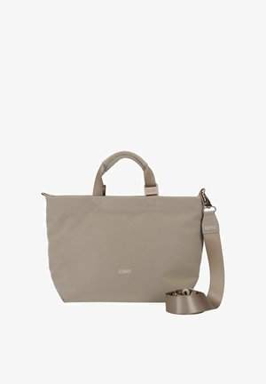 Beige Tragetasche mit glatter Textur, zwei Griffen und einem verstellbaren Riemen. Sie verfügt über ein dezentes Logo auf der Vorderseite und einen Reißverschluss.