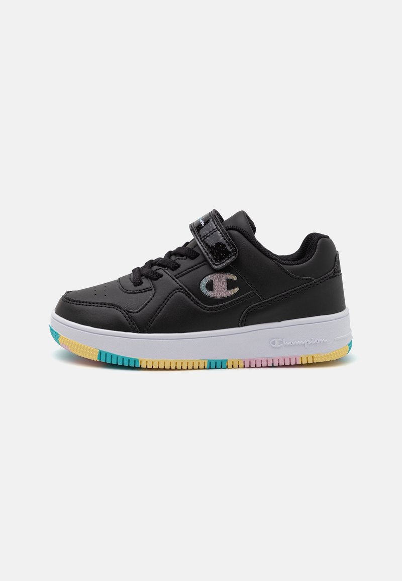 Baskets basses noires avec lacets, une bride en velcro, un logo irisé, une semelle blanche et des parties de semelle multicolores en bleu, jaune et rose.