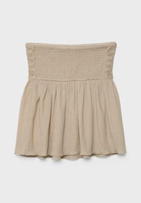 Robe mini beige sans bretelles avec corsage smocké et jupe froncée, comportant des panneaux en dentelle sur les côtés du haut.