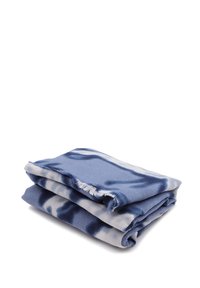 Coperta in pile blu e bianca, piegata. Presenta un motivo ondulato con una texture morbida e bordi sfrangiati. Forma rettangolare. Materiale leggero.