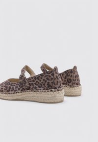 Espadrilles de estampado de leopardo con parte superior de tela, correa ajustable y suela de yute natural. Diseño bajo con un acabado texturizado.